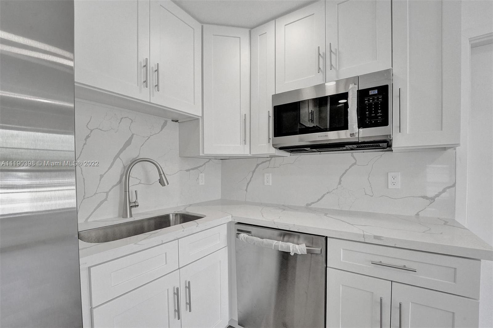 730 Northwest 18th Street Pompano Beach, FL 33060 - Photo 10 of 56 a kitchen with stainless steel appliances white cabinets and a sink