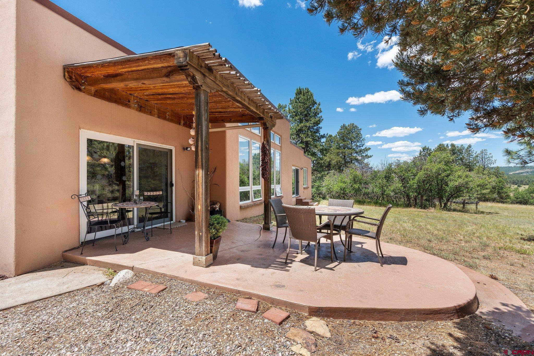 285 South Fork Road Durango, CO 81303 - Photo 24 of 31 a view of a patio with a table and chairs under an umbrella