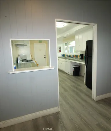 a large kitchen with cabinets wooden floor and stainless steel appliances