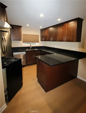 a kitchen with stainless steel appliances granite countertop a stove a sink and a refrigerator