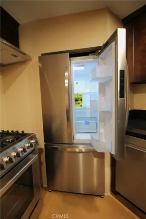 a kitchen with stainless steel appliances granite countertop a refrigerator and a stove