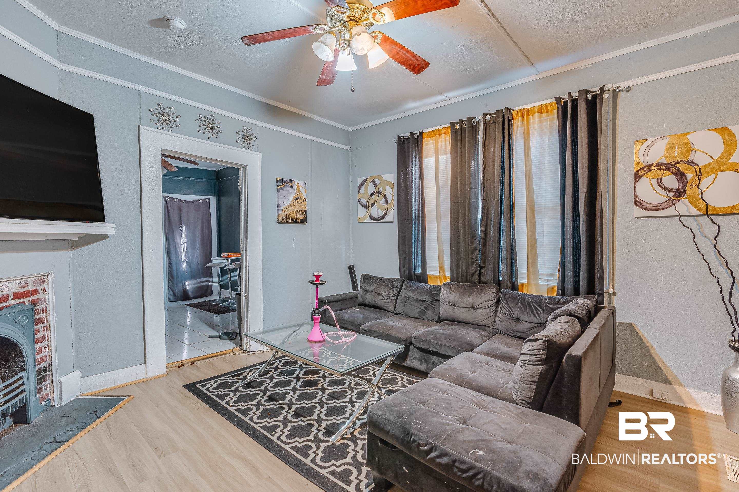 14 Southern Street Mobile, AL 36611 - Photo 3 of 26 Living room with ceiling fan, ornamental molding, hardwood / wood-style floors, and a wood stove