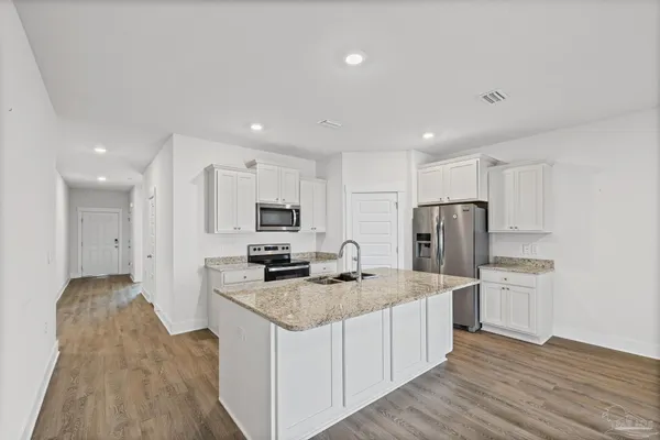 a kitchen with granite countertop a refrigerator and a sink