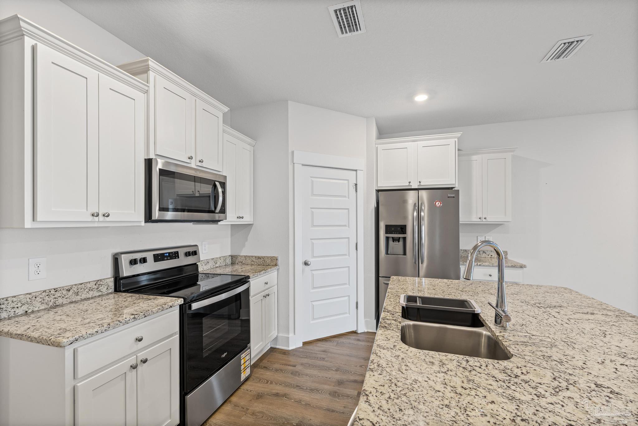 4074 Blaney Lane Pace, FL 32571 - Photo 40 of 59 a kitchen with granite countertop a refrigerator stove and microwave