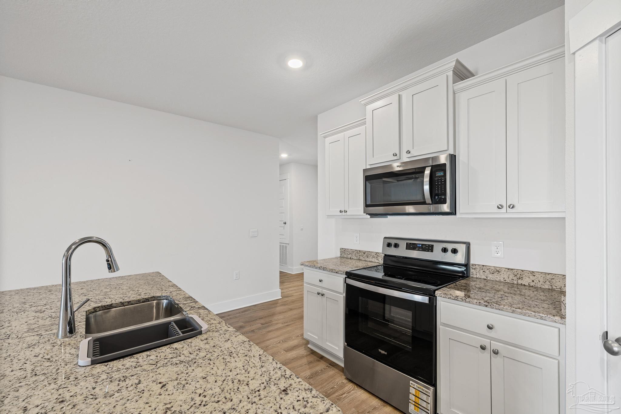 4074 Blaney Lane Pace, FL 32571 - Photo 43 of 59 a kitchen with sink a stove and microwave