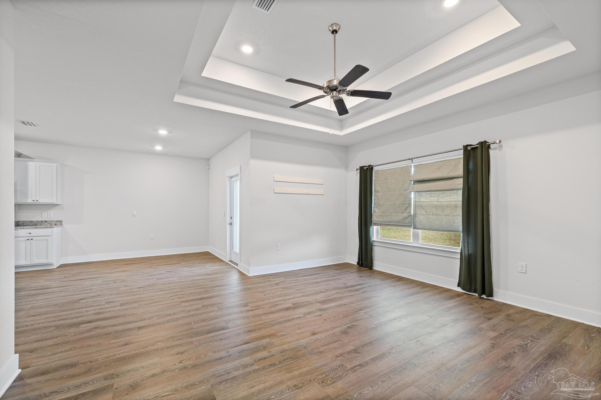 4074 Blaney Lane Pace, FL 32571 - Photo 48 of 59 a view of an empty room with wooden floor and a ceiling fan