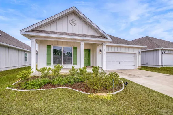 a front view of a house with a garden and plants