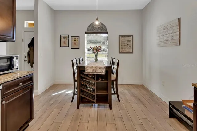a dining room with furniture a chandelier and wooden floor