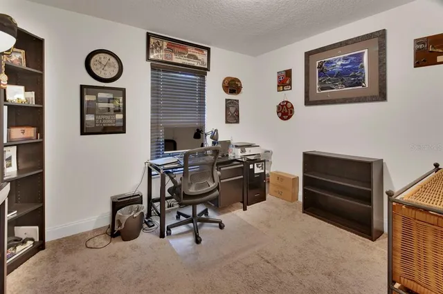 a view of a workspace with furniture and a window
