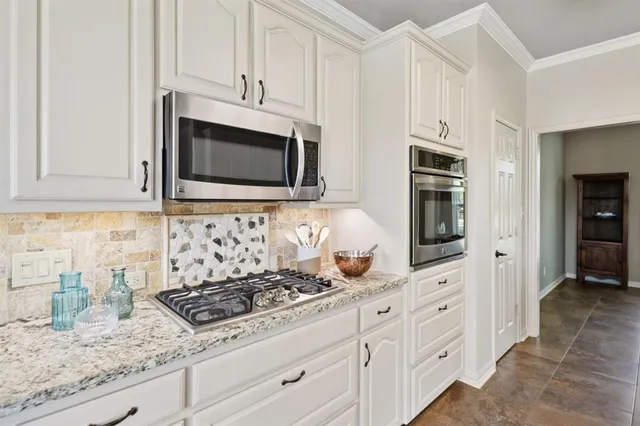 a kitchen with stainless steel appliances granite countertop a stove a refrigerator and a refrigerator