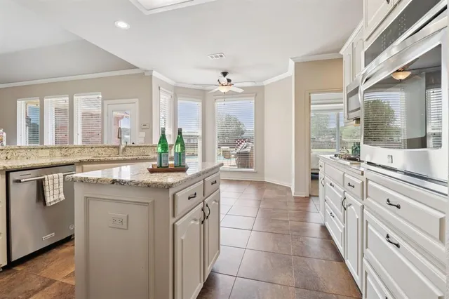 a kitchen with granite countertop white cabinets and stainless steel appliances