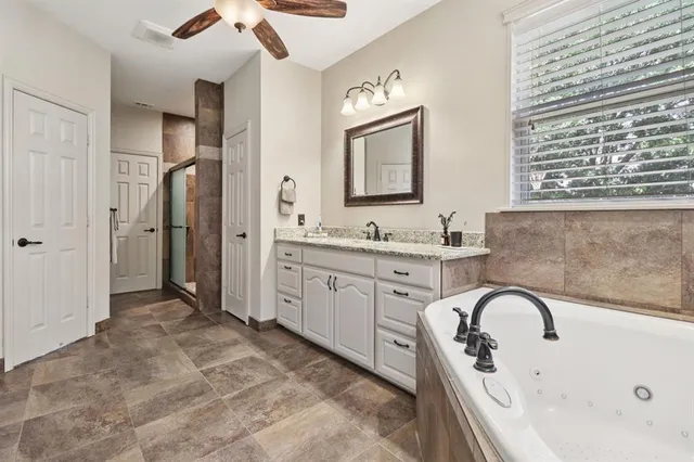 a spacious bathroom with a double vanity sink a mirror and a bathtub