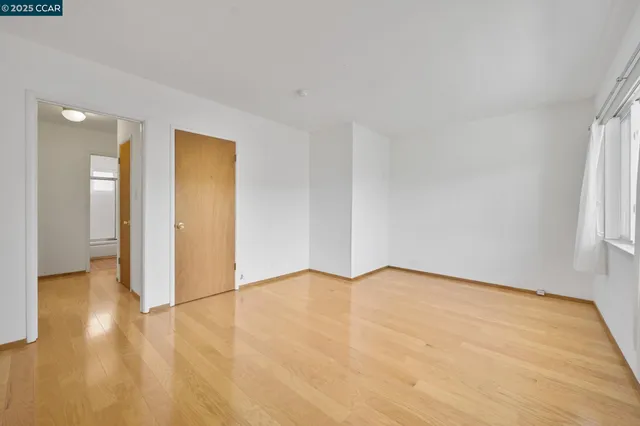 a view of an empty room and wooden floor