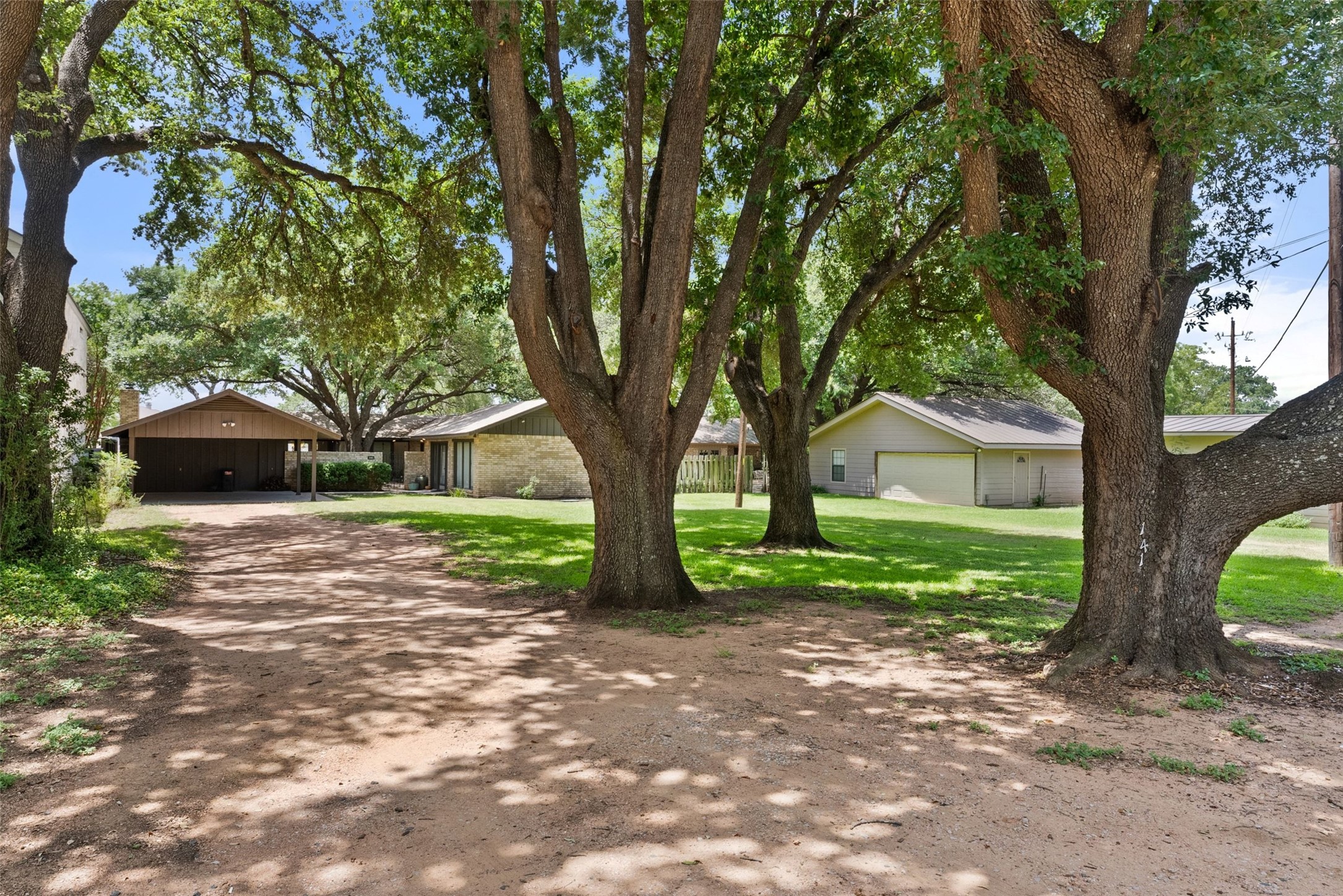 141 Perry Lane Kingsland, TX 78639 - Photo 38 of 40 Mature trees canopy the inviting driveway leading to this charming residence, offering serene outdoor living.