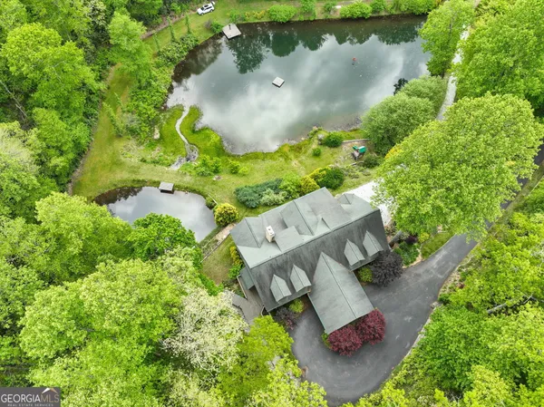an aerial view of a house with a yard and lake view