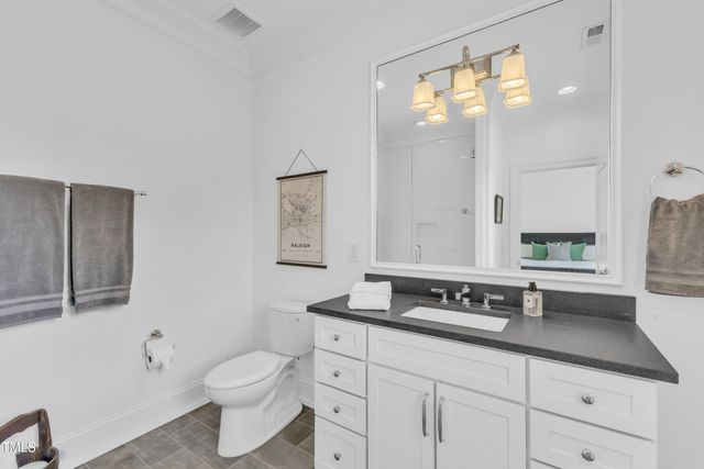 a bathroom with a granite countertop sink a toilet and mirror