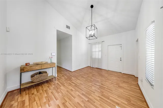 a view of a room with wooden floor and ceiling fan