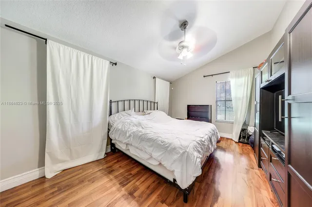 a spacious bedroom with a bed and a flat screen tv