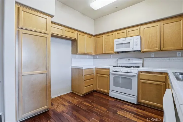 a kitchen with cabinets appliances and wooden floor