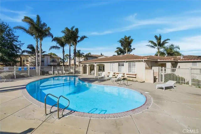 a view of a swimming pool with a lounge chair and palm trees