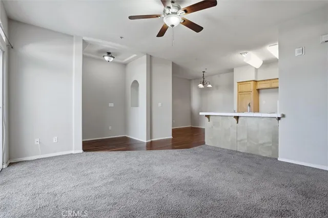 a view of an empty room and kitchen view