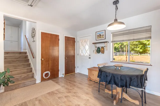 a dining room with wooden floor a chandelier a wooden table and chairs