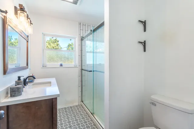 a bathroom with a sink toilet and window