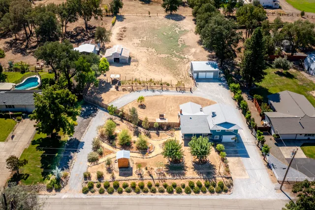 an aerial view of a house with a garden and trees