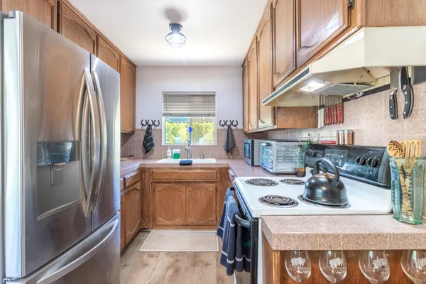 a kitchen with stainless steel appliances granite countertop a stove a refrigerator and a sink