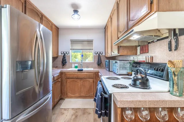 a kitchen with stainless steel appliances granite countertop a stove a refrigerator and a sink