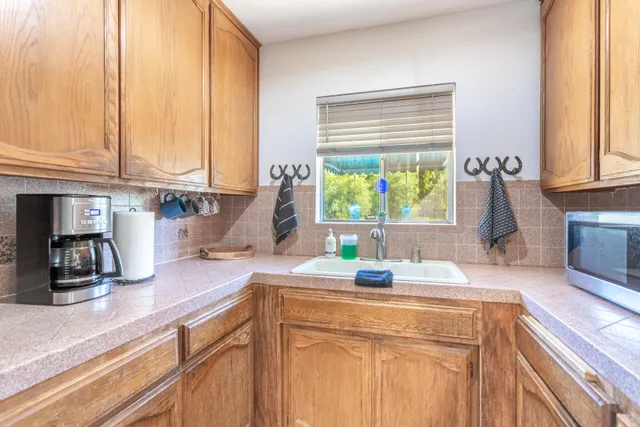 a kitchen with kitchen island granite countertop a sink a counter cabinets and a window