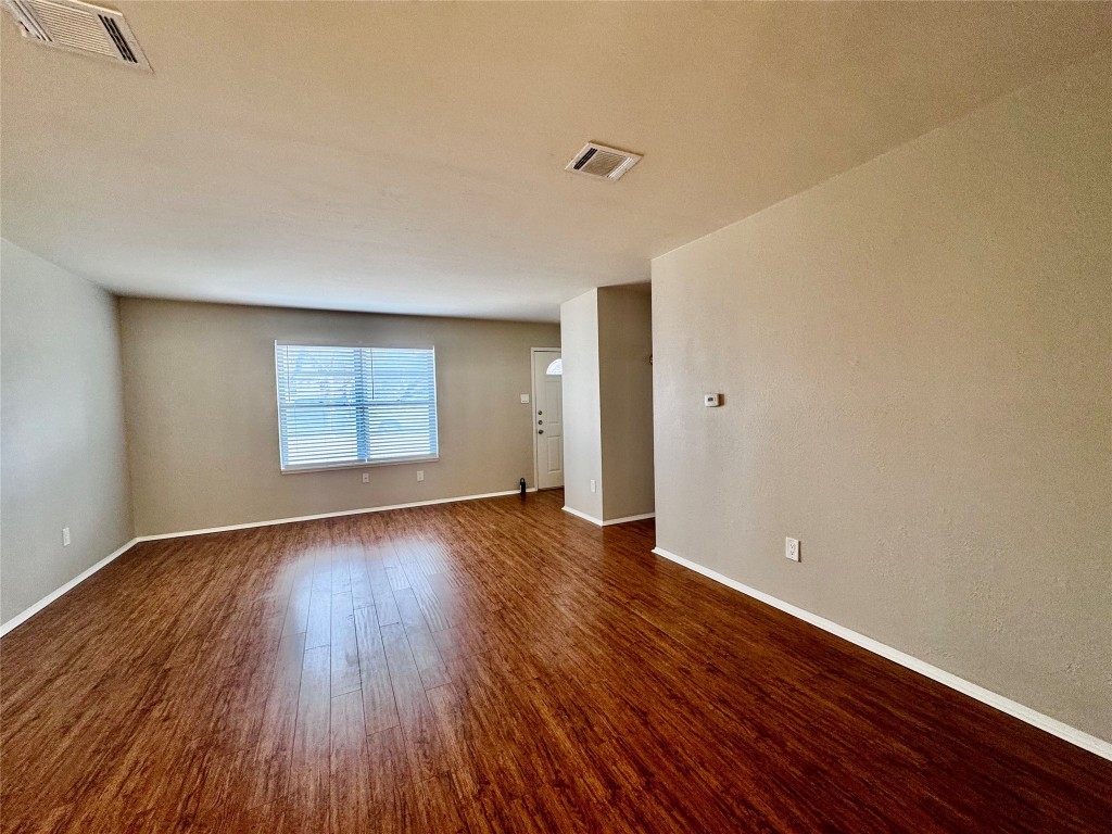 744 Wales Way Austin, TX 78748 - Photo 2 of 15 an empty room with wooden floor and windows