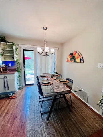 a view of a dining room with furniture wooden floor and a chandelier