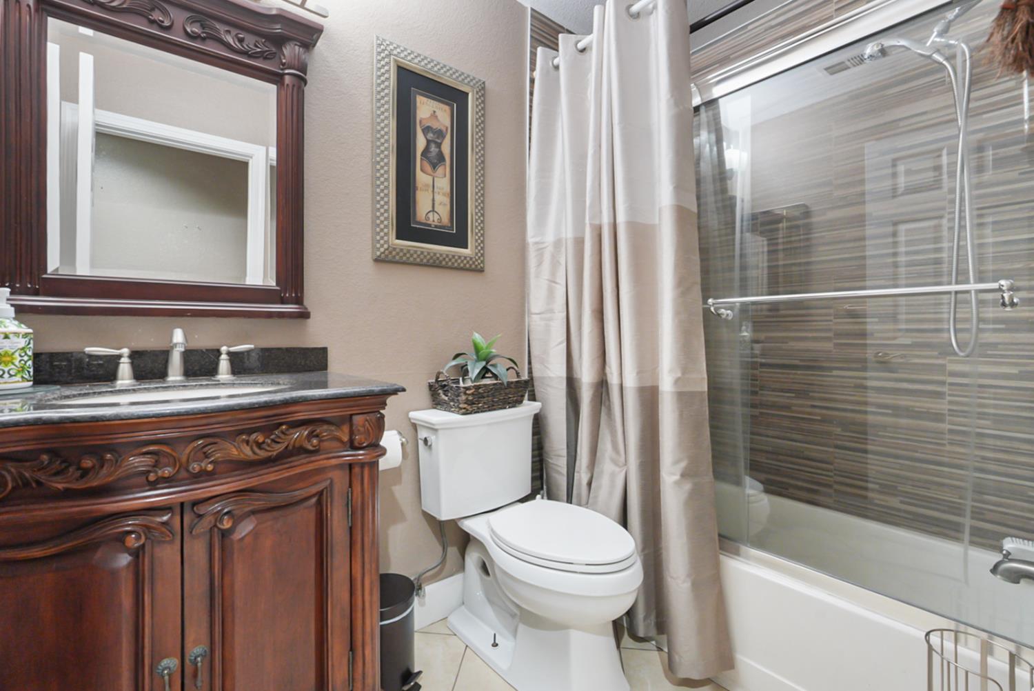 1421 Riverette Drive Modesto, CA 95351 - Photo 14 of 32 a bathroom with a sink a toilet a mirror and shower