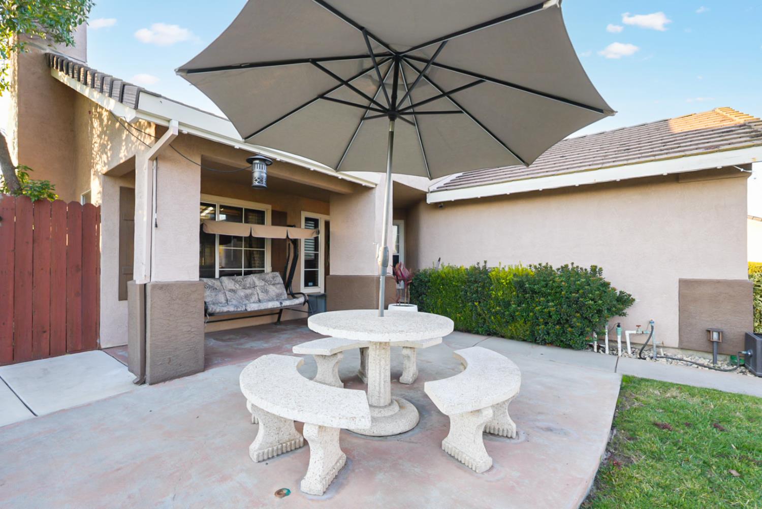 1421 Riverette Drive Modesto, CA 95351 - Photo 4 of 32 a view of a patio with a table and chairs under an umbrella