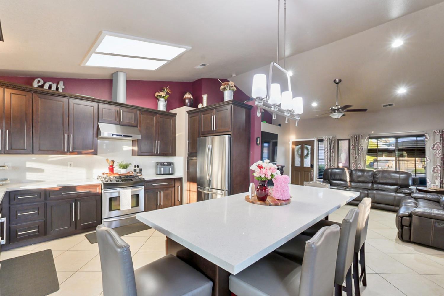 1421 Riverette Drive Modesto, CA 95351 - Photo 7 of 32 a kitchen with kitchen island a stove a sink dishwasher and white cabinets with wooden floor