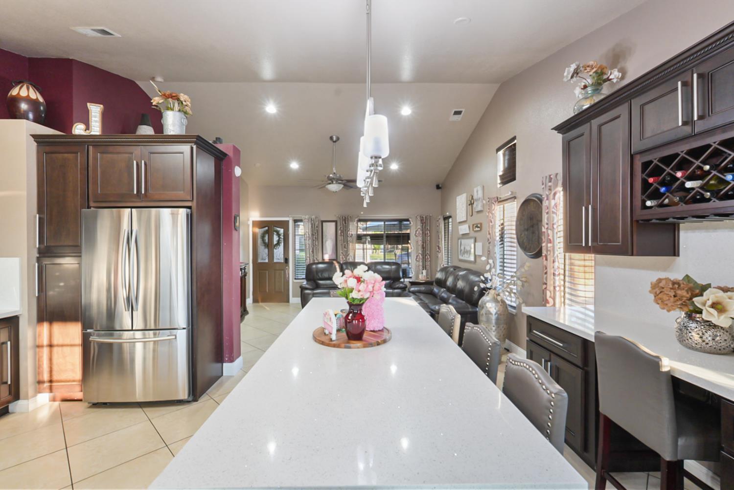 1421 Riverette Drive Modesto, CA 95351 - Photo 10 of 32 a large kitchen with stainless steel appliances kitchen island granite countertop a refrigerator and a view of living room