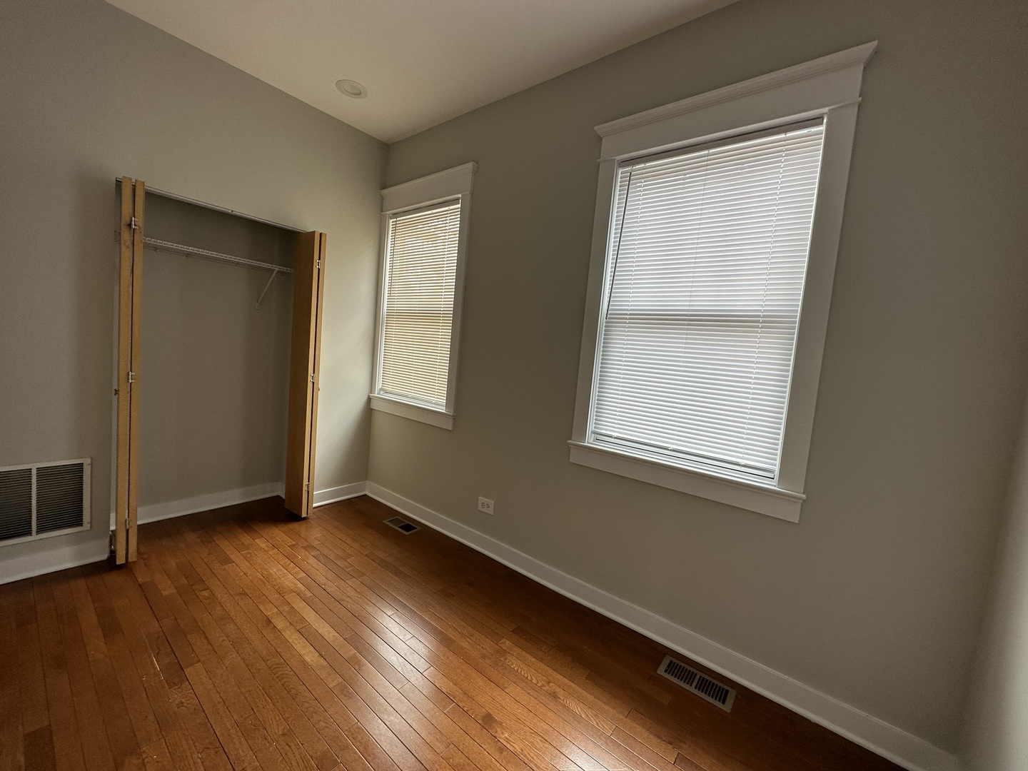 Undisclosed Address Chicago, IL 60613 - Photo 5 of 12 an empty room with wooden floor and windows