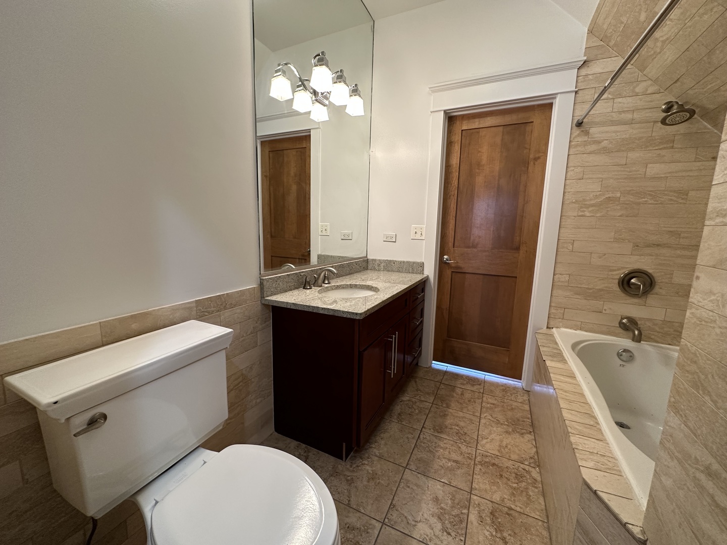 Undisclosed Address Chicago, IL 60613 - Photo 10 of 12 a bathroom with a bathtub shower sink vanity and toilet