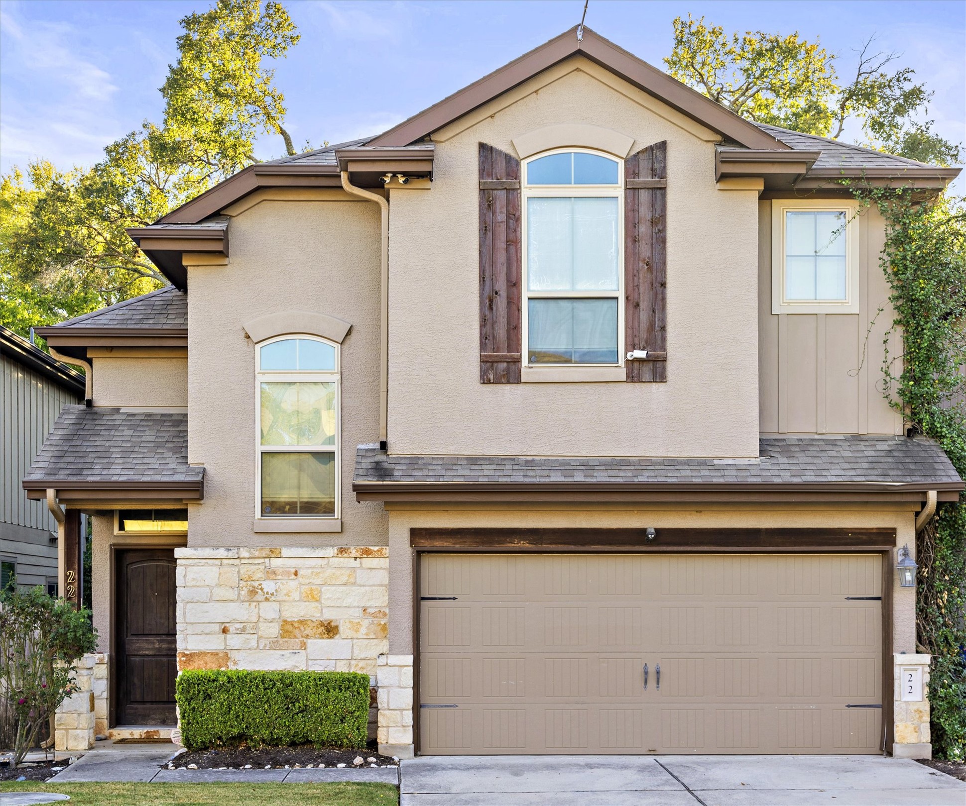 View of front of house, showing front entrance, featuring 2 car garage, driveway, a shingled roof, and stone siding