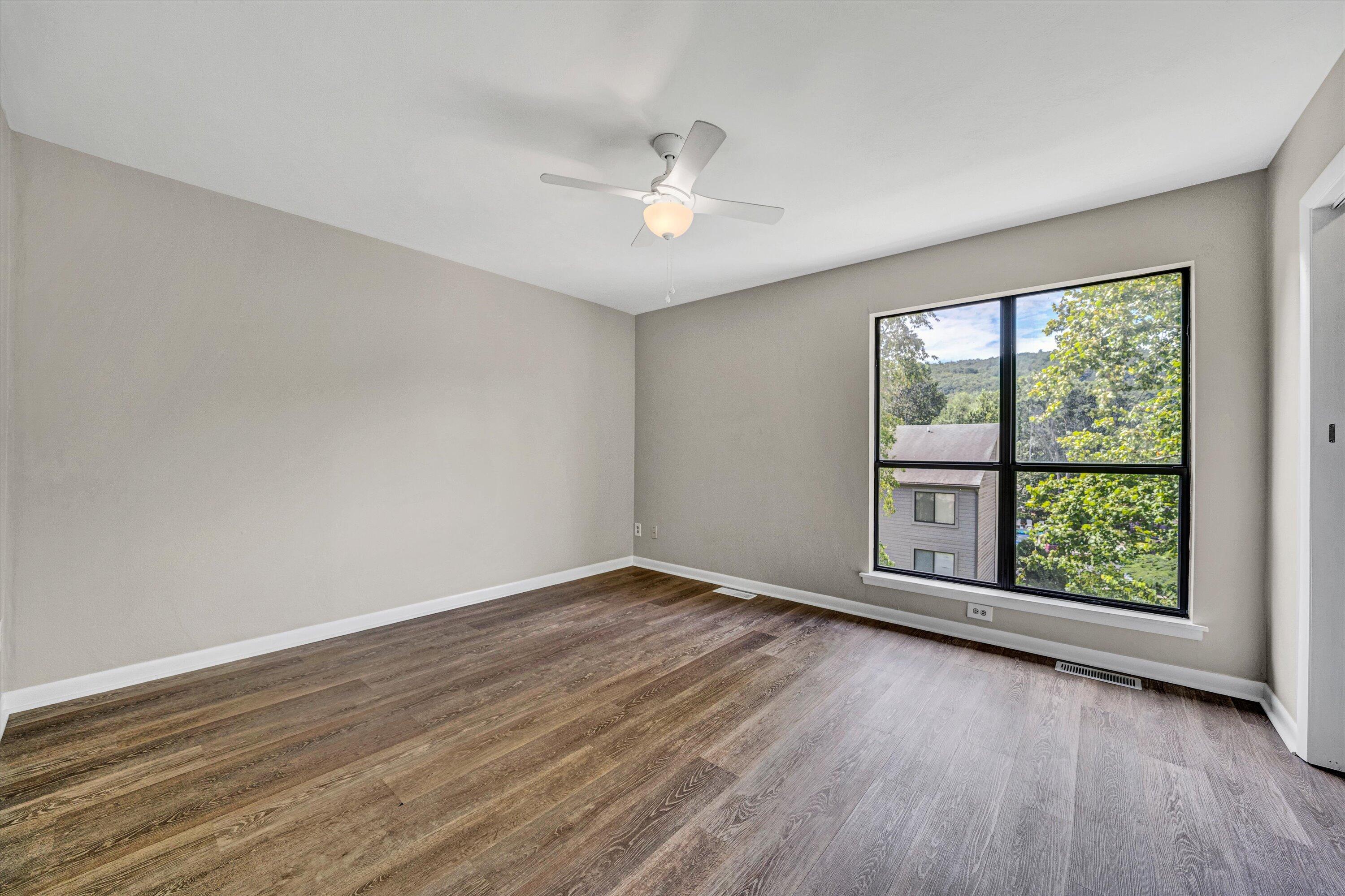 7311 Maple Court Southwest Roanoke, VA 24018 - Photo 25 of 41 an empty room with wooden floor and windows