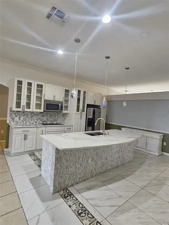 a large kitchen with stainless steel appliances kitchen island granite countertop a sink and cabinets