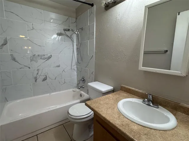 a bathroom with a granite countertop sink mirror toilet and bathtub