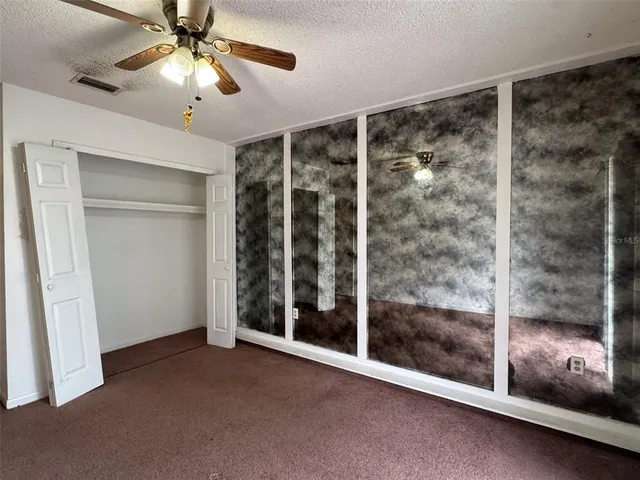 a view of a room with window and ceiling fan