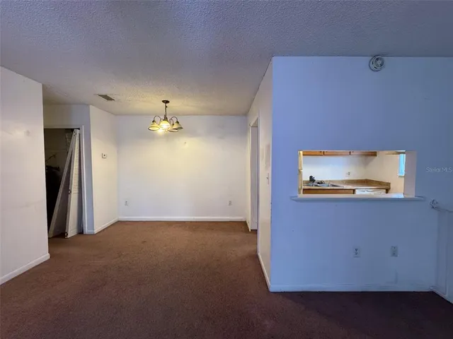 an empty room with a ceiling fan and window