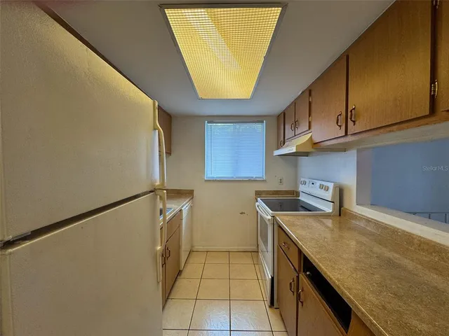 a kitchen with a sink a refrigerator and cabinets