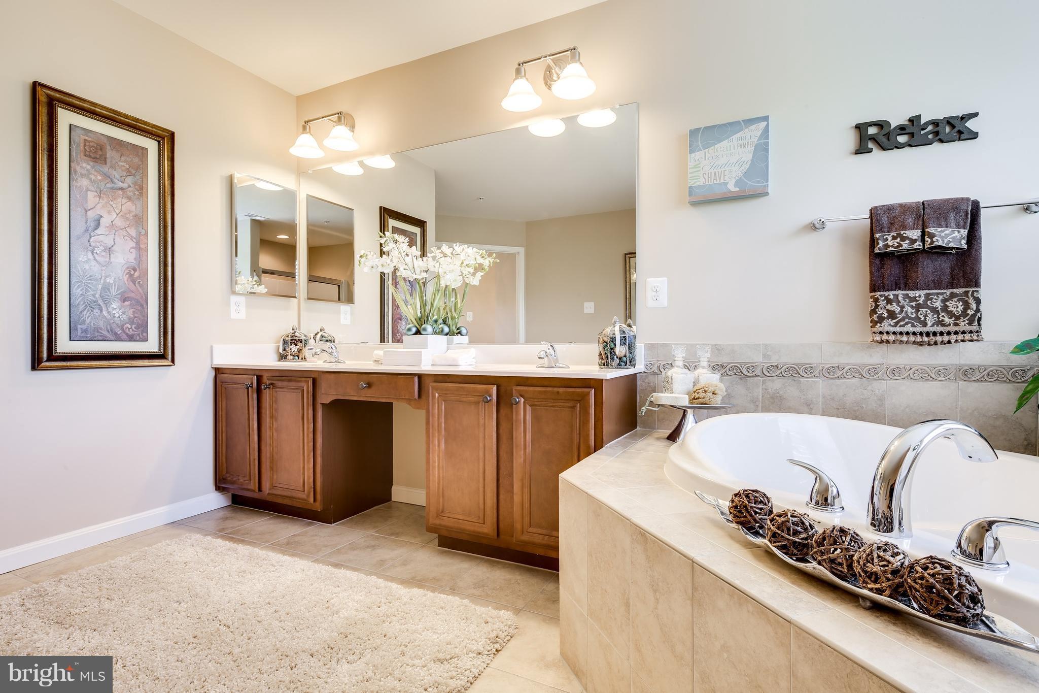 6020 Cypress Springs Road Elkridge, MD 21075 - Photo 23 of 29 a spacious bathroom with a tub a double vanity sink and a mirror
