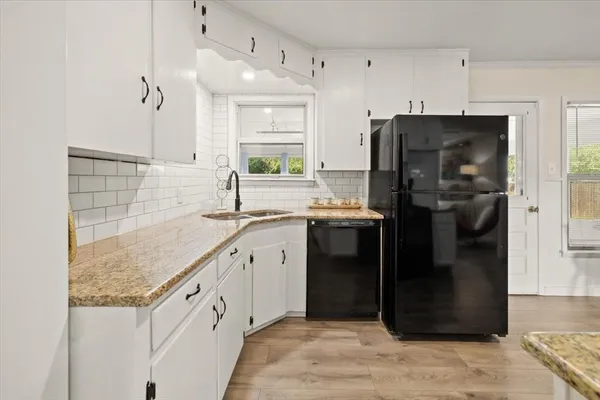 a kitchen with stainless steel appliances granite countertop a refrigerator a stove and a sink