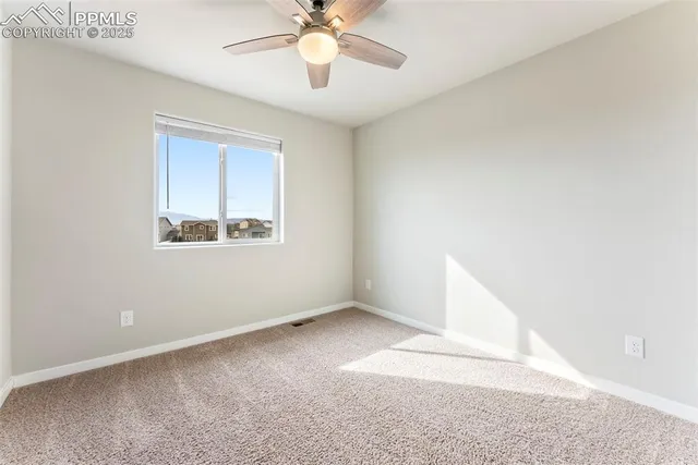 a view of an empty room with window and closet