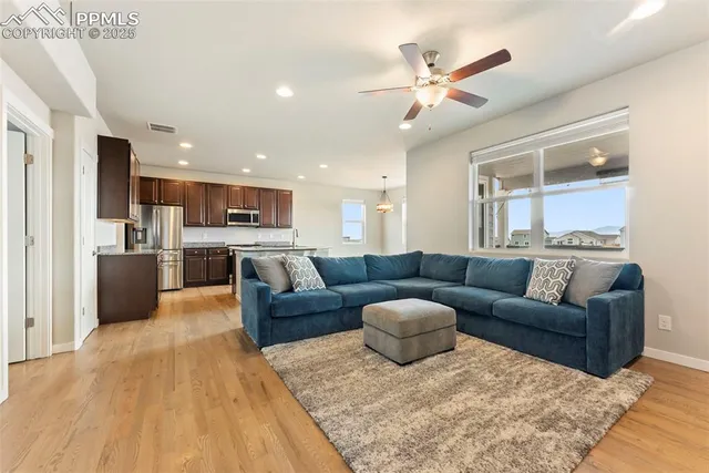 a living room with furniture kitchen view and a chandelier